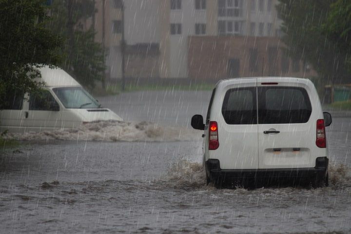 Un vehículo circula bajo la lluvia en Valencia
