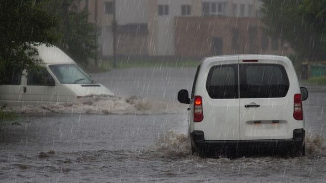 Un vehículo circula bajo la lluvia en Valencia