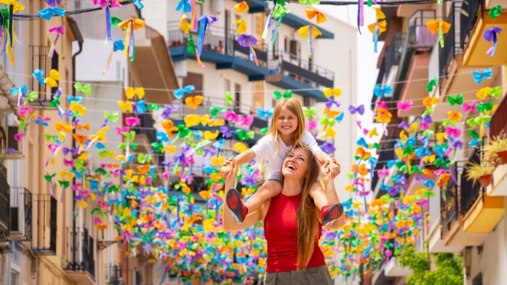 Una madre y su hija pasean pasean por un centro histórico de Benissa repleto banderolas de colores Una madre y su hija pasean pasean por un centro histórico de Benissa repleto banderolas de colores