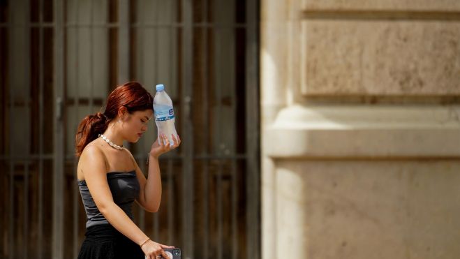 Una mujer por la calle en una ola de calor Una mujer por la calle en una ola de calor