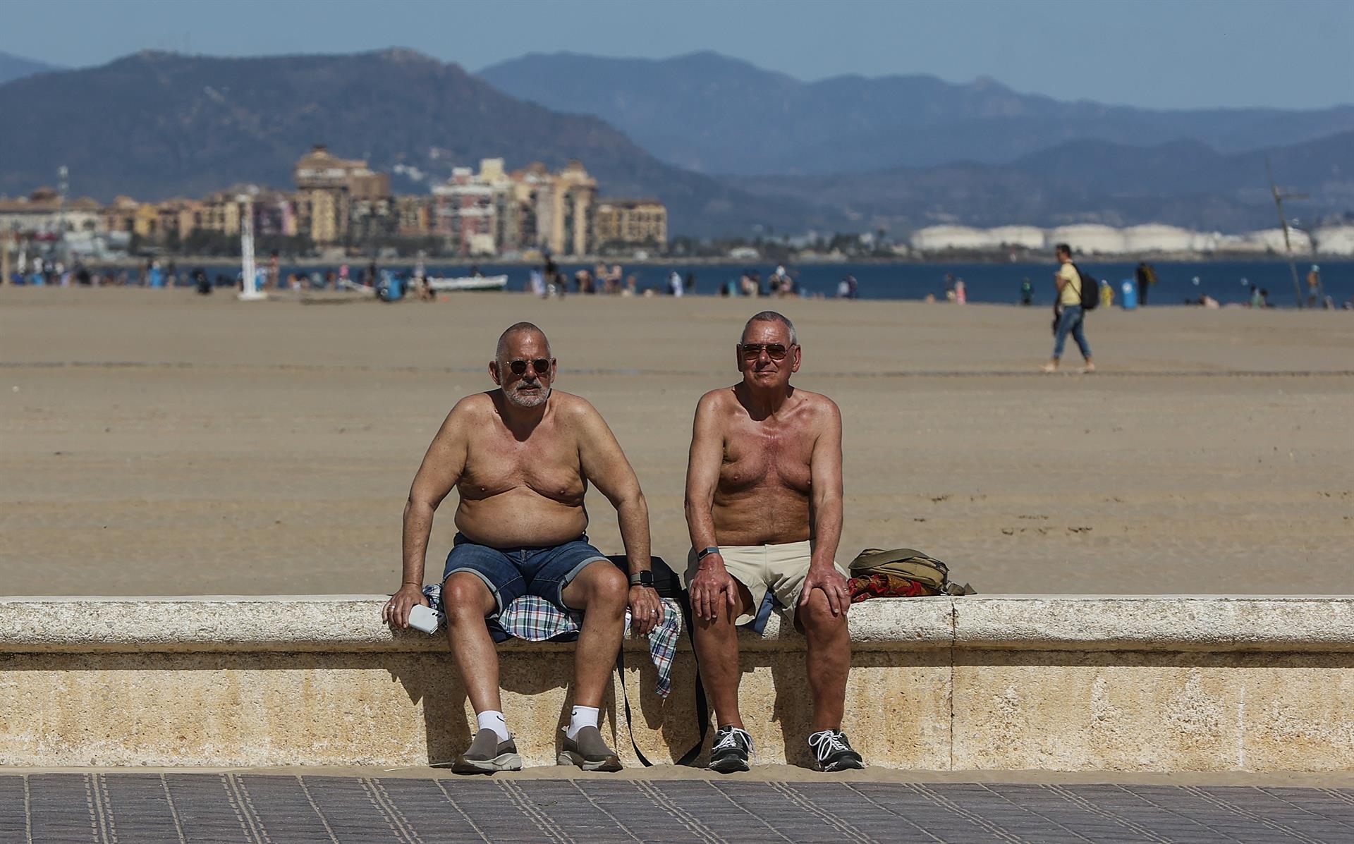 Dos personas en la playa en la ola de calor en Valencia