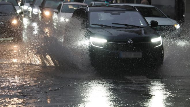 Un coche circula con lluvia en la carretera Un coche circula con lluvia en la carretera