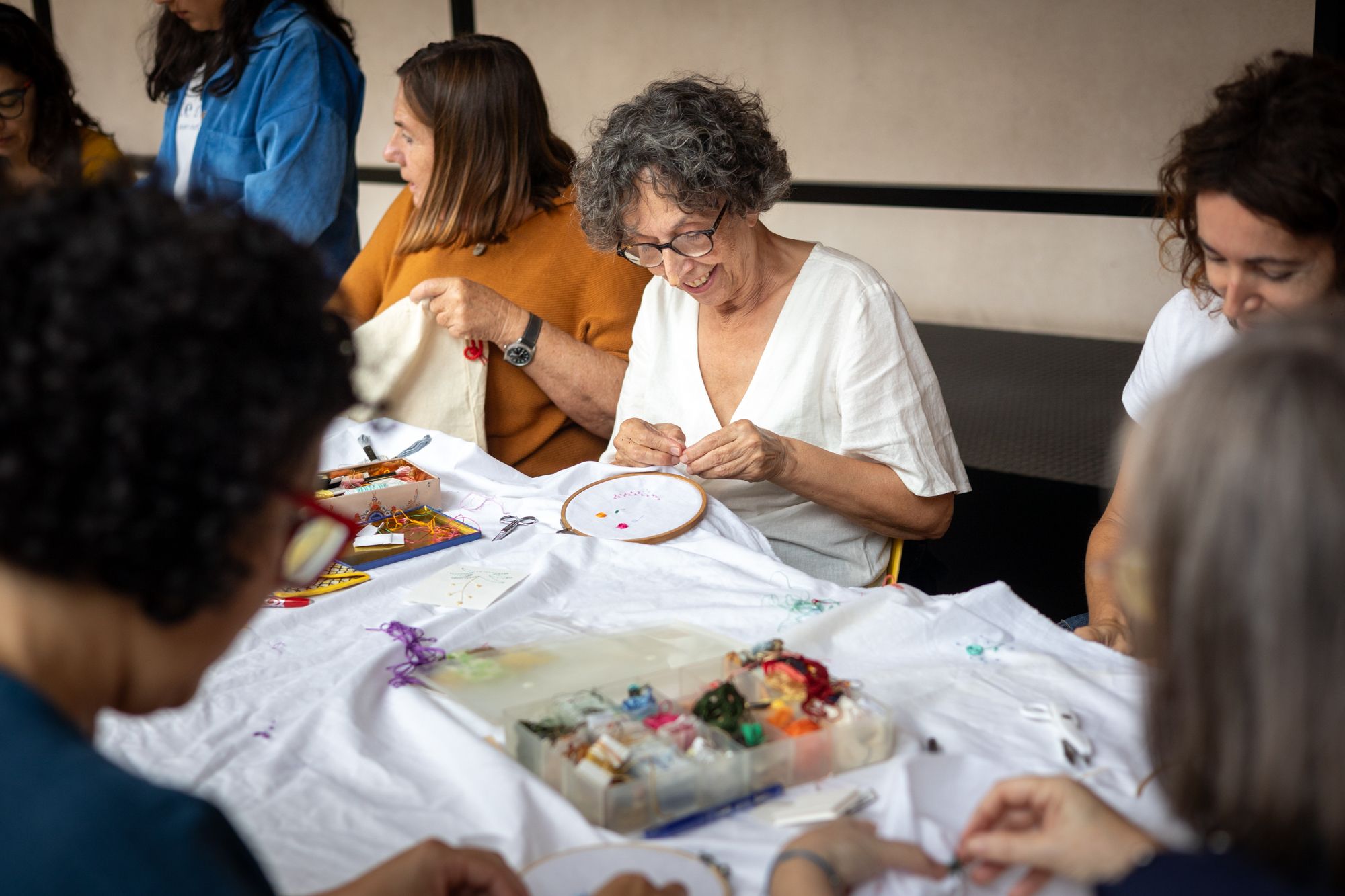 Persones majors participant en una activitat tèxtil del Programa d'Educació i Mediació del Centre del Carme