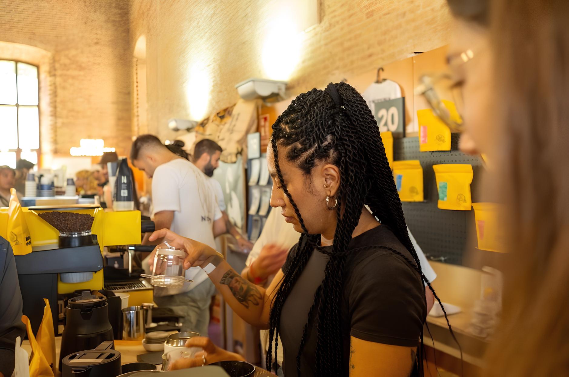 Una chica sirve café en Valencia is Coffee