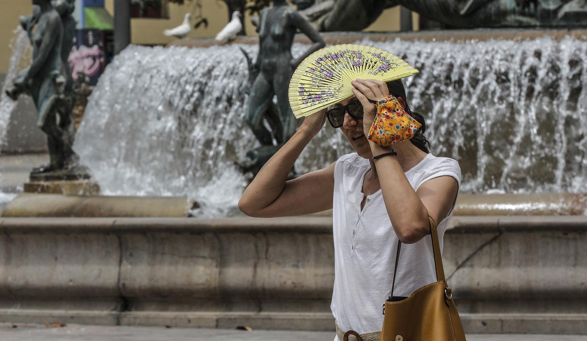 Una dona es protegix del sol en plena onada de calor Una dona es protegix del sol en plena onada de calor