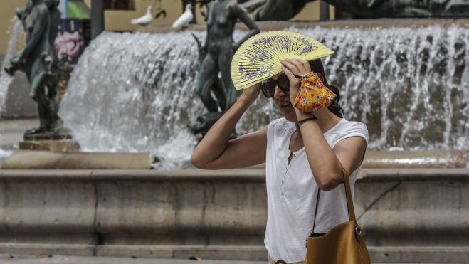 Una mujer se protege del sol en plena ola de calor Una mujer se protege del sol en plena ola de calor