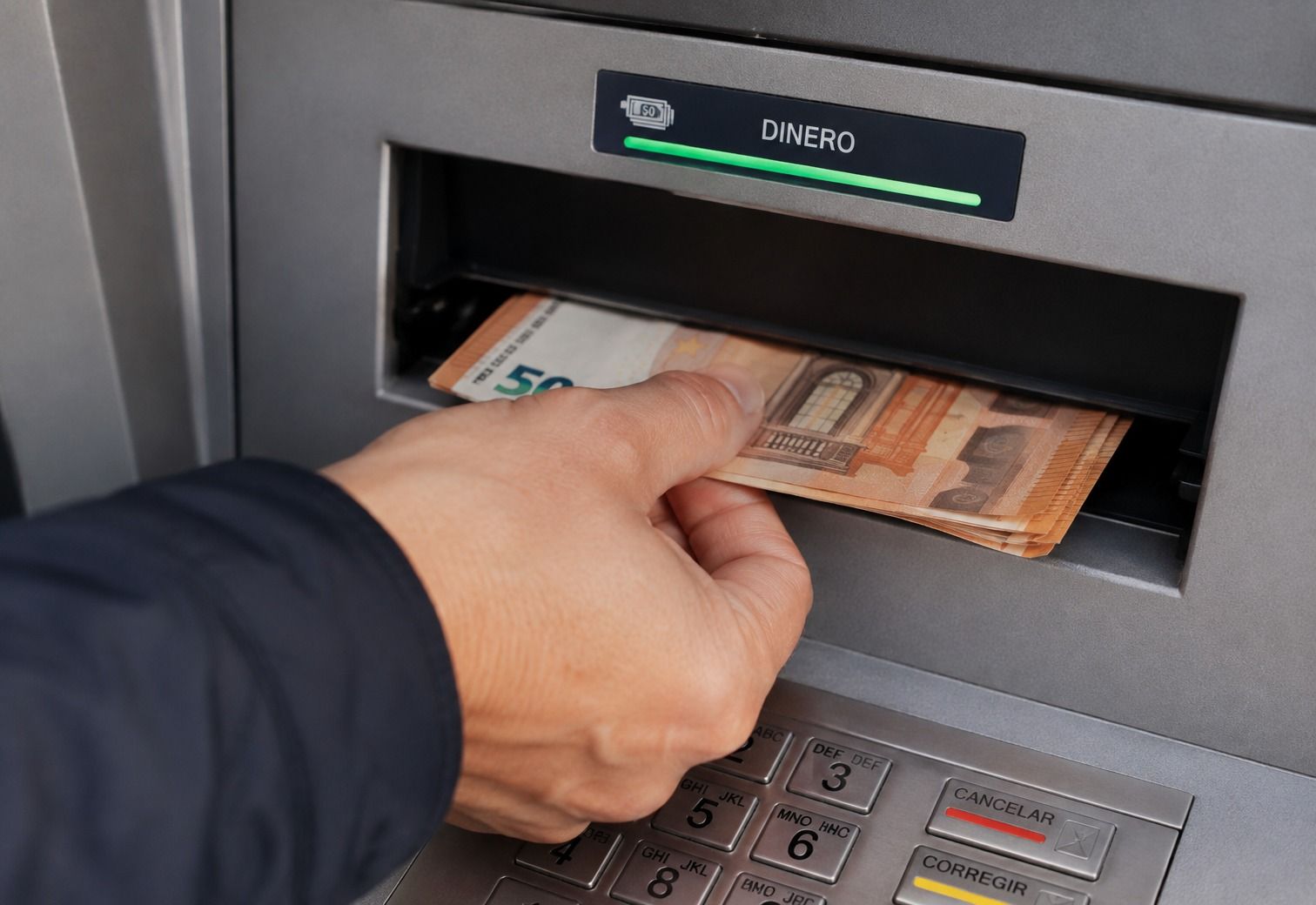 Una persona retira diners en un caixer