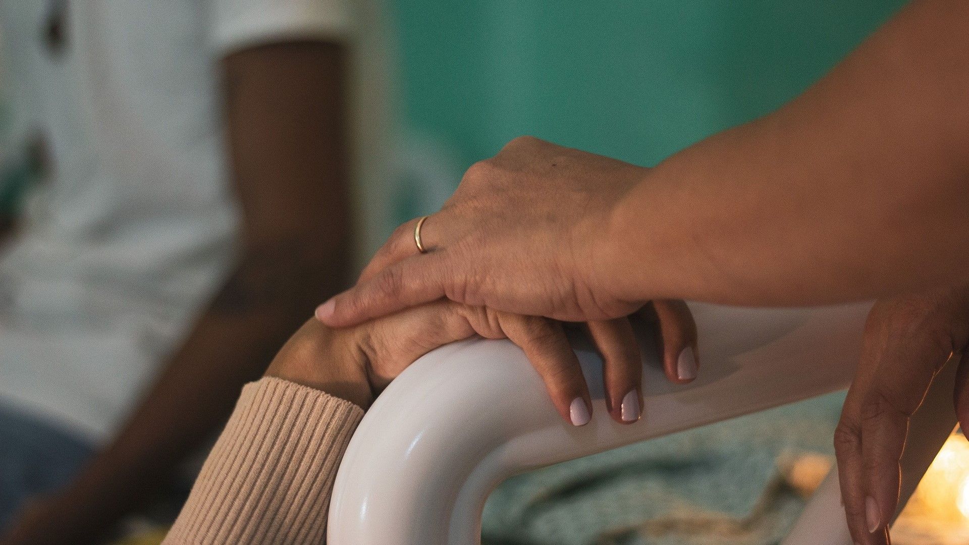Una mujer cogiéndole la mano a una anciana Una mujer cogiéndole la mano a una anciana