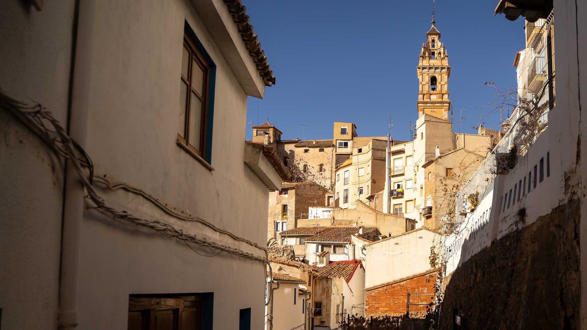 Calle estrecha de Chelva con el campanario de fondo