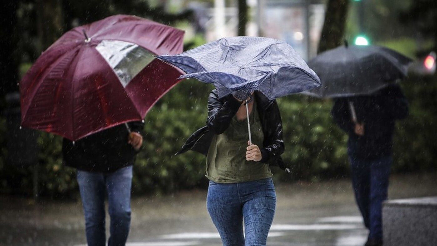 Varias personas con paraguas bajo la lluvia 