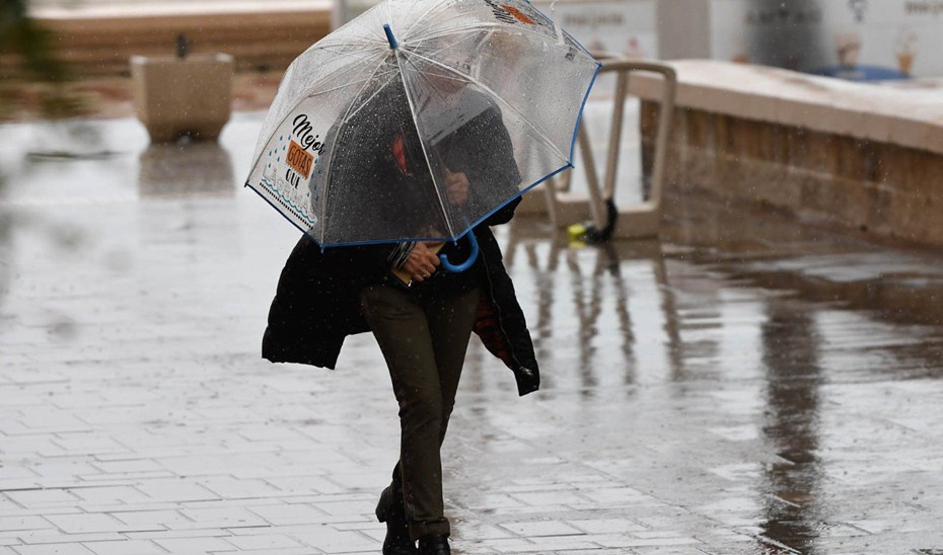 Una mujer con paraguas por la lluvia Una mujer con paraguas por la lluvia